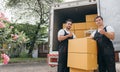 Efficient workers in uniform unload boxes from the moving truck ensuring a Royalty Free Stock Photo