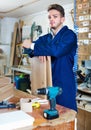 Man measuring boards for furniture at workshop