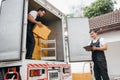 Efficiently working together removal service employees unload boxes and Royalty Free Stock Photo