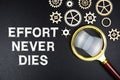 Effort Never Dies text message with magnifying glass on black background Royalty Free Stock Photo