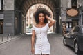 Effortless beauty. Attractive young Afro American woman in short white dress playing with hair and smiling Royalty Free Stock Photo