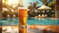 efreshing light cold beer in a transparent glass, set against the backdrop of the sunlit poolside and the azure sky. Royalty Free Stock Photo