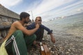 ÃÅ¡efugee shaves the other on the beach. Many refugees come from Royalty Free Stock Photo