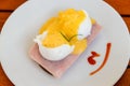 Poached egg on ham slices and a piece of bread - Egg benedict on white dish on breakfast Royalty Free Stock Photo