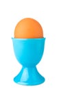 Egg in blue egg cup isolated on white Royalty Free Stock Photo