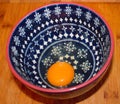 Egg in a blue pattern bowl on wood surface Royalty Free Stock Photo