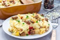 Egg casserole with potatoes, sausage and pepper, on white plate, horizontal