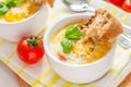 Egg cocotte in white ramekin with tomato and basil