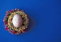 An egg with a cute painted face on a classic blue background. The classic blue flower is the trendy color of the year Royalty Free Stock Photo