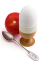 Egg in eggcup, a teaspoon and tomato