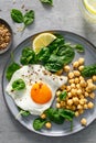 Egg fried, boiled chickpea and fresh spinach for healthy breakfast, top view