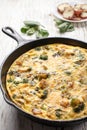 Egg frittata baked in cast iron skillet with a plate of potatoes Royalty Free Stock Photo