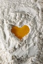 Egg heart on flour. I love to bake! Close-up of yolk on flour in the shape of a heart, full frame Royalty Free Stock Photo