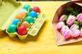 Egg hunt. painted eggs in egg tray. Spring holiday. Holiday celebration, preparation. Tulip flower bouquet. Healthy and