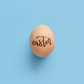 Egg with inscription EASTER over light blue background Royalty Free Stock Photo