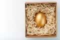 Egg made of gold in a wooden box on a white background. The concept of exclusivity and superprize. Minimalistic composition Royalty Free Stock Photo