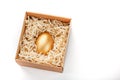 Egg made of gold in a wooden box on a white background. The concept of exclusivity and superprize. Minimalistic composition Royalty Free Stock Photo