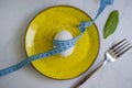 Egg, measuring tape, lettuce leaf in a plate