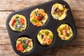 Egg muffins omelet with bacon, tomatoes, spinach and mushrooms close-up in a baking dish. Horizontal top view Royalty Free Stock Photo