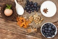 Egg in a nest, blueberries, flour in bowl, dried apricot, nuts, cinnamon sticks and anise on wooden background Royalty Free Stock Photo