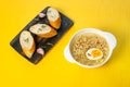 Egg noodles on a yellow background, bread and garlic on a wooden board
