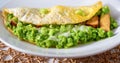 Egg omelette, mashed fresh green pea, celery stalk, smoked tofu on white plate on bamboo pad, closeup Royalty Free Stock Photo