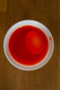 Egg in a plastic cup to get colored in red for easter Royalty Free Stock Photo