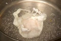 An egg poaching in boiling water Royalty Free Stock Photo