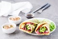 Egg rolls filled with pastrami, vegetables and green onions on a plate, sprouted grains and soy sauce in bowls on the table. Royalty Free Stock Photo