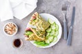 Egg rolls filled with pastrami, vegetables and green onions on a plate, sprouted grains and soy sauce in bowls on the table. Royalty Free Stock Photo