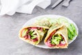 Egg rolls filled with pastrami, vegetables and green onions on a plate on the table. Hearty and high-calorie snack Royalty Free Stock Photo