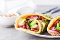 Egg rolls filled with pastrami, vegetables and green onions on a plate on the table. Hearty and high-calorie snack. Close-up Royalty Free Stock Photo