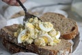 egg salad being spooned onto whole wheat bread Royalty Free Stock Photo