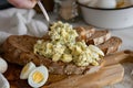egg salad being spooned onto whole wheat bread Royalty Free Stock Photo