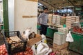 Egg seller looking at a stray cat and her kitten in the center of the Skopje Bazaar Green market