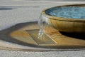 Egg-shaped fountain from which water flows. bowl with clear blue water waterfall on the square. flows through a decorative recesse