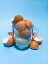 Egg Shells and Raw Rice in a transparent glass on a blue background Royalty Free Stock Photo