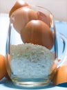 Egg Shells and Raw Rice in a transparent glass on a blue background Royalty Free Stock Photo