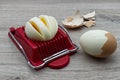 Egg slicer tool with boiled egg on wooden table Royalty Free Stock Photo