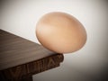 Egg standing at the edge of the table. 3D illustration Royalty Free Stock Photo