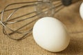 An Egg and whisk isolated on table mat Royalty Free Stock Photo
