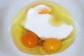 Egg yolks in a white bowl with sugar