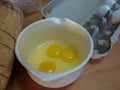 Egg yolks and whites in bowl with egg carton and sliced bread Royalty Free Stock Photo