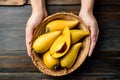 Eggfruit or canistel in a basket holding by hand