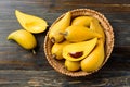 Eggfruit or canistel in a basket on wooden table