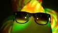 Egghead man in sunglasses in the multicolored spotlight