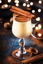 Eggnog cocktail hot winter or autumn drink with milk, eggs and dark rum, sprinkled with cinnamon and nutmeg in shot glass on blue Royalty Free Stock Photo