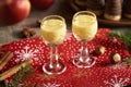 Eggnog in two small glasses with apples and Christmas cookies