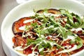 Eggplant carpaccio in tomato sauce with arugula, pomegranate seeds and walnuts topped with white dressing