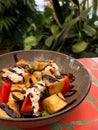 Eggplant with feta cheese and vegetables in a round gray plate